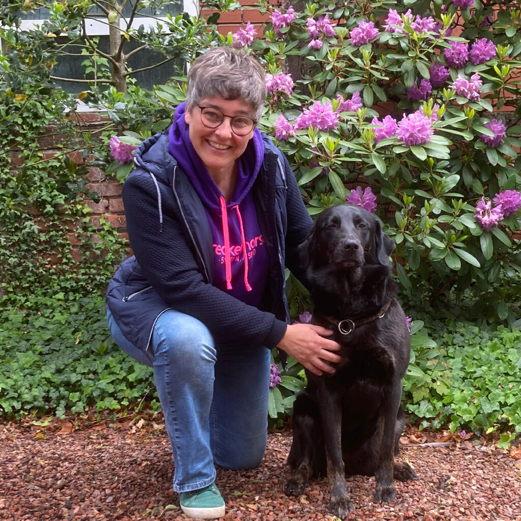 Katja Finkenbrink im Garten mit einem Hund